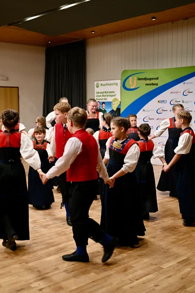 Die Kindertrachtengruppe tanzt Hand in Hand in einer offenen Runde
