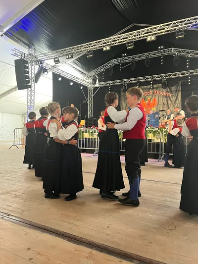 Tanzpaare der Kindertrachtengruppe tanzen im Festzelt vor der Bühne
