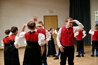 Kinder in Tracht halten bei einer Tanzfigur die Hand über die Augen
