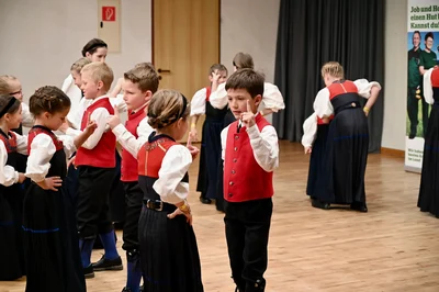 Kinder in Tracht heben bei einer Tanzfigur den Zeigefinger