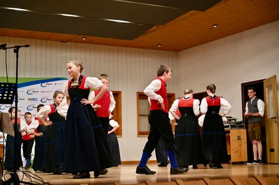Tanzende Kinder in Tracht, die Hände in die Hüften gestützt