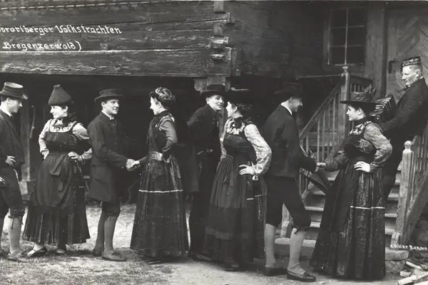 Historische Aufnahme: Bregenzerwälder Trachten vor einem Wälderhaus